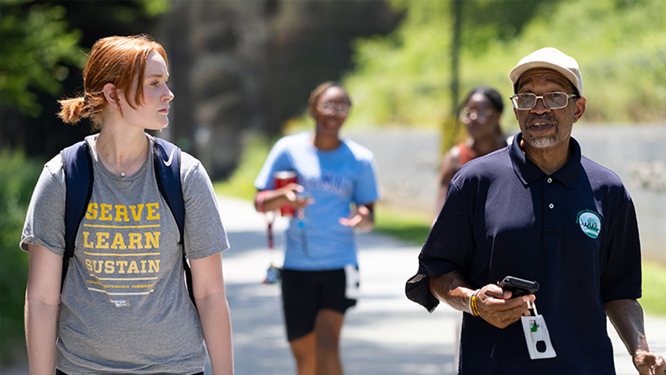 Ben Gray talking to a student while walking outside